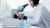Chemist looking through microscope